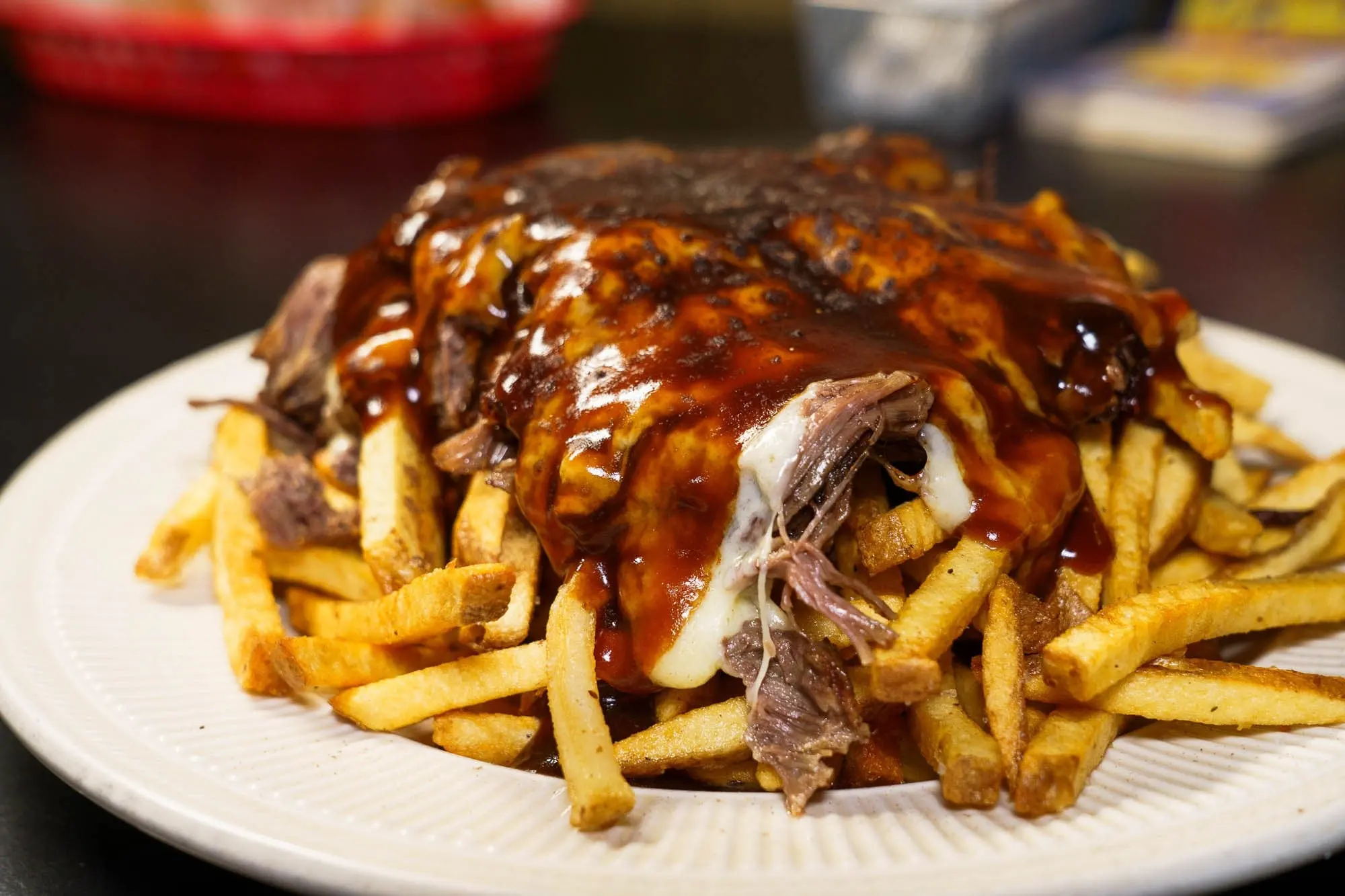 Truffled short-rib poutine: hand-cut fries piled with braised short rib, cheese curds and glossy demi-glace on a white plate